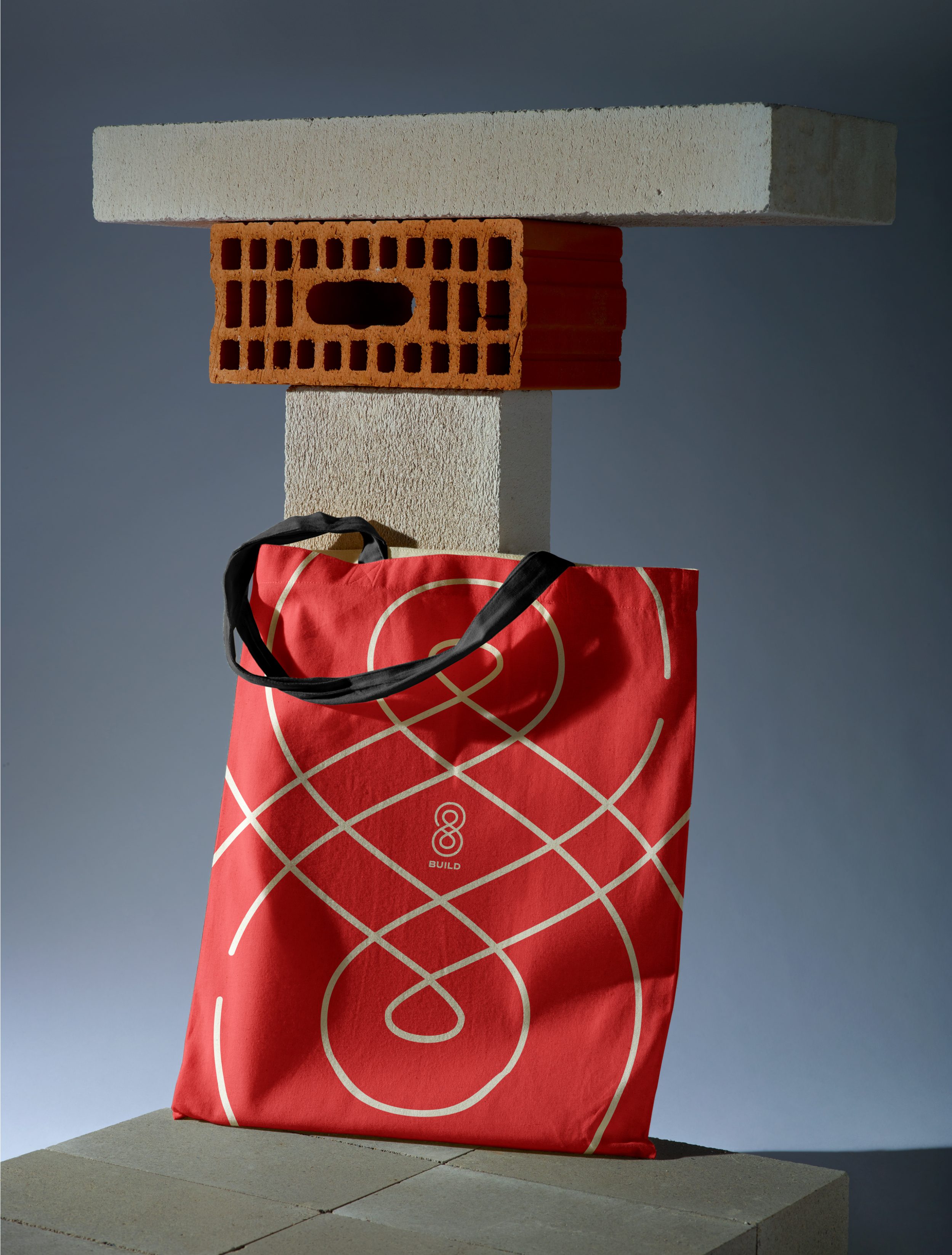Red tote bag resting on breeze blocks