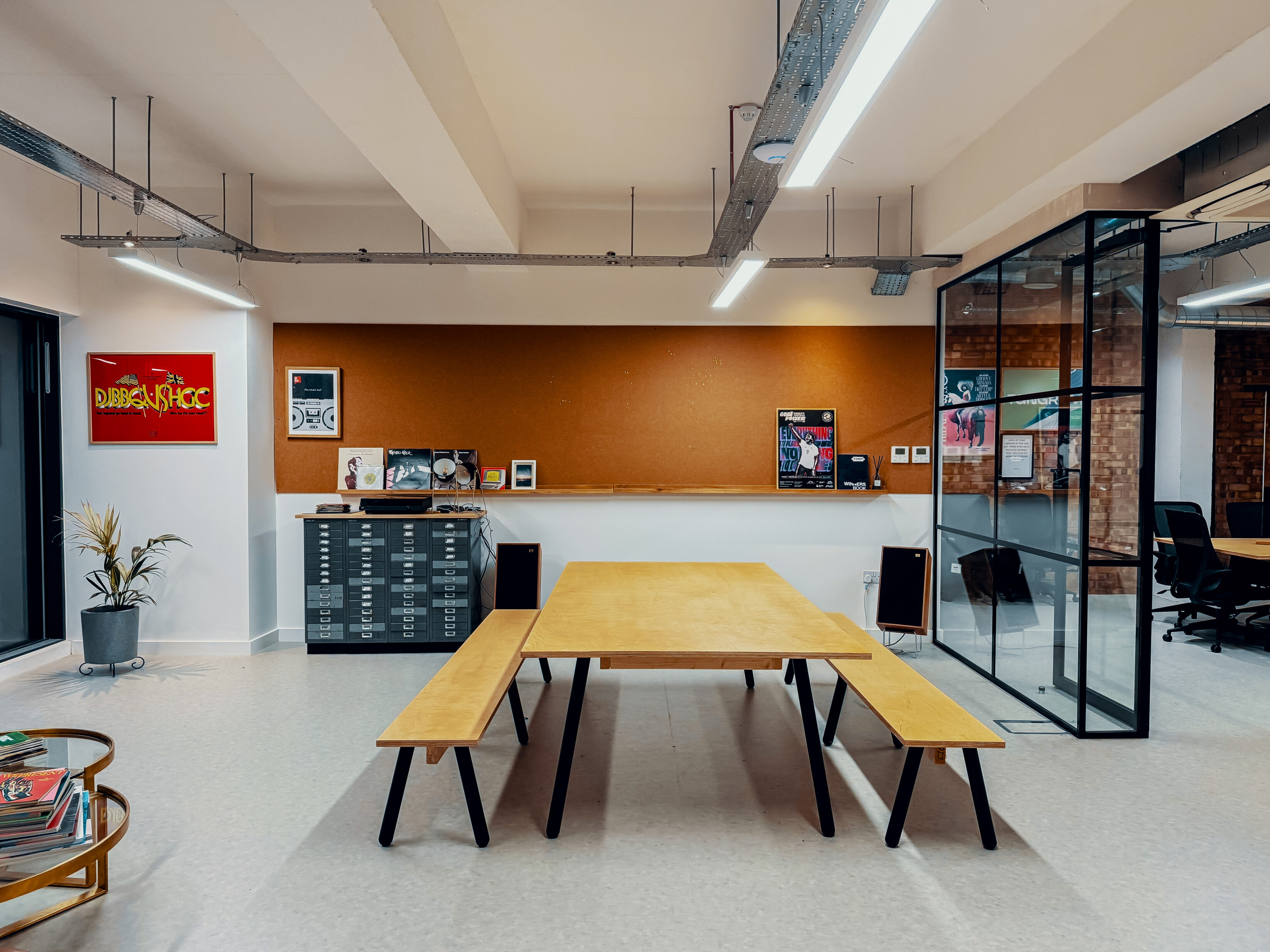 Breakout space showing large corkboard and picnic style bench that comfortably seats eight