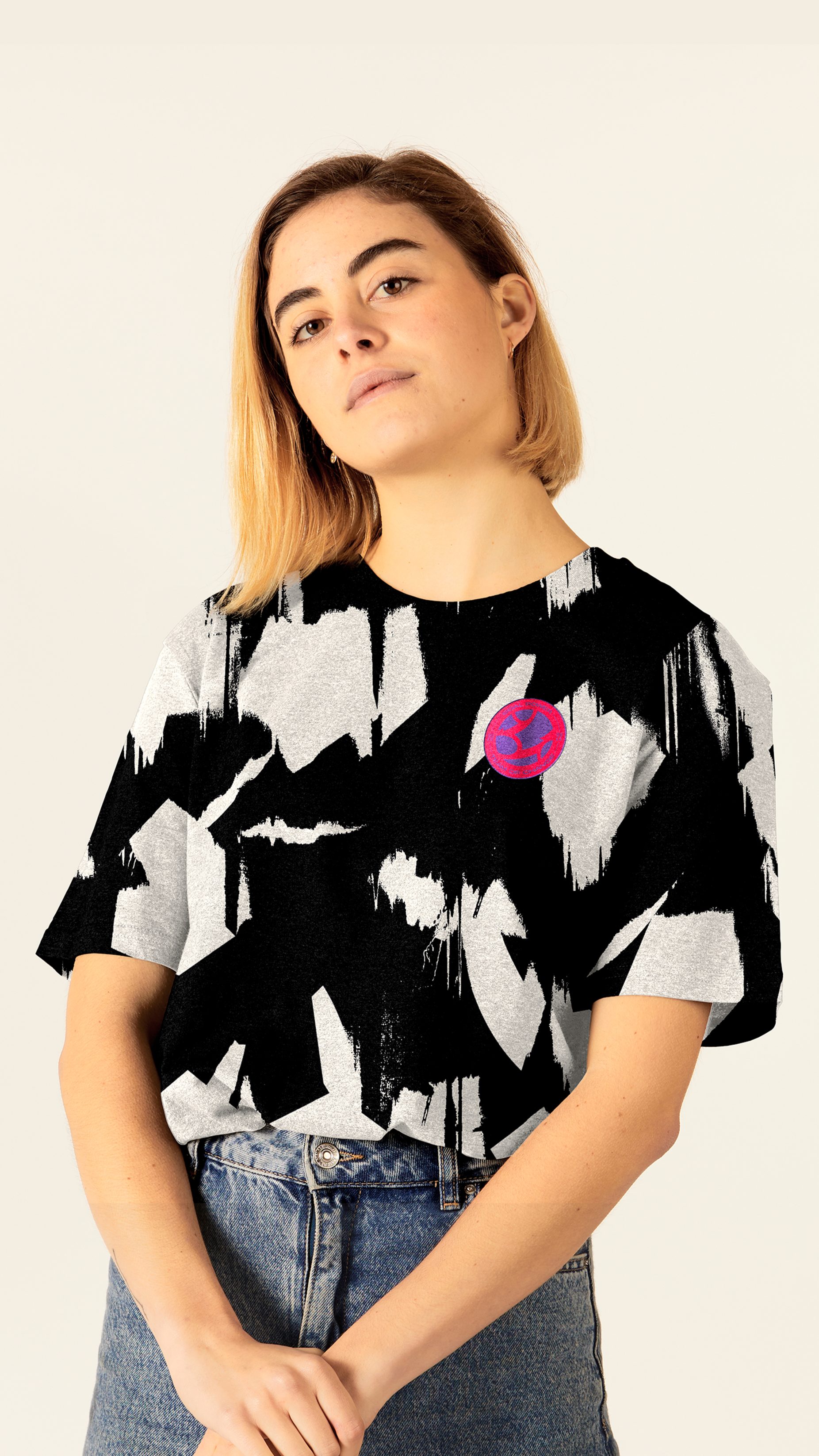 A confident woman wearing a branded Goal Power t-shirt tucked into her vintage jeans.