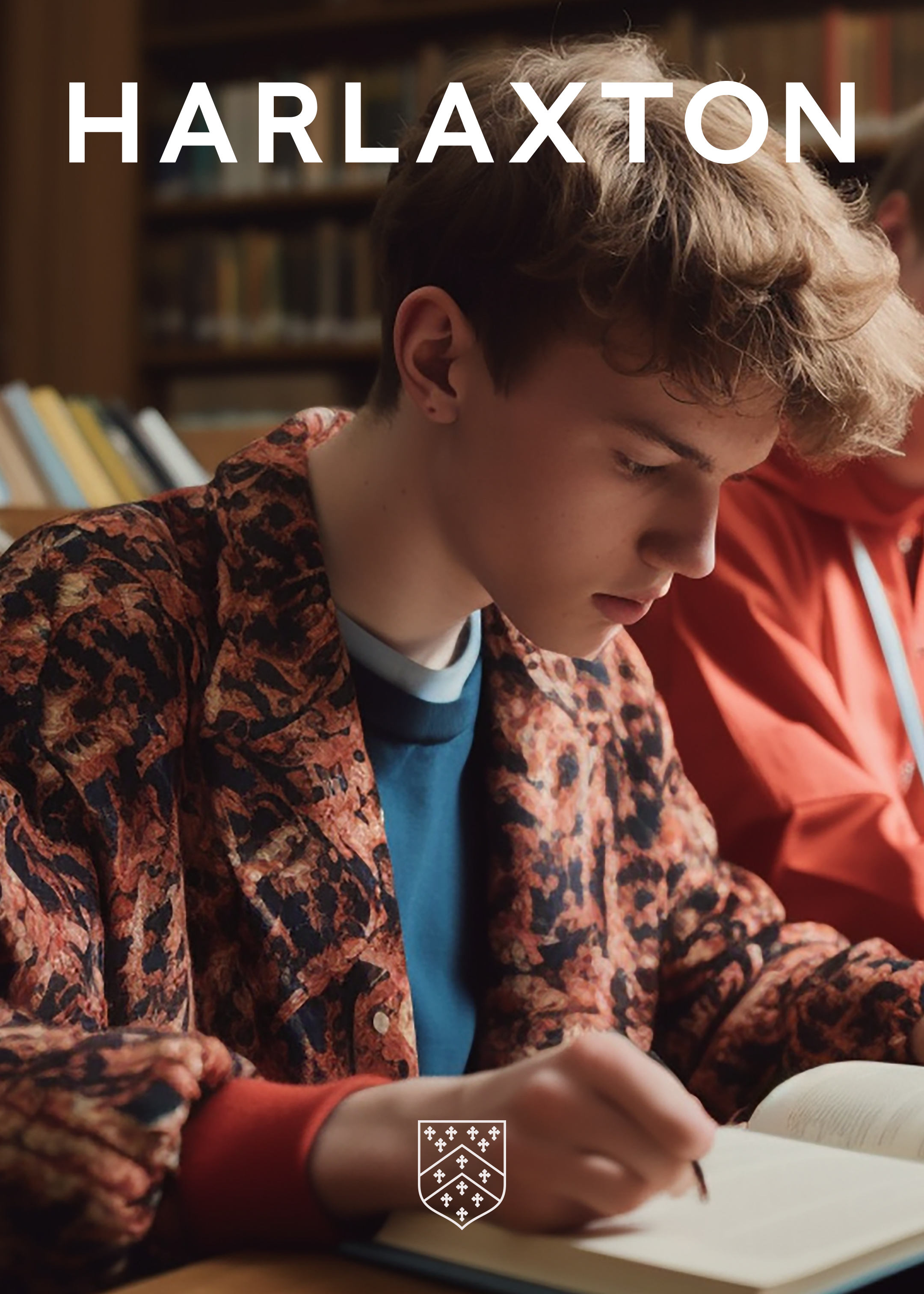 Young male working at a desk, with the wordmark at the top, and shield at the bottom.