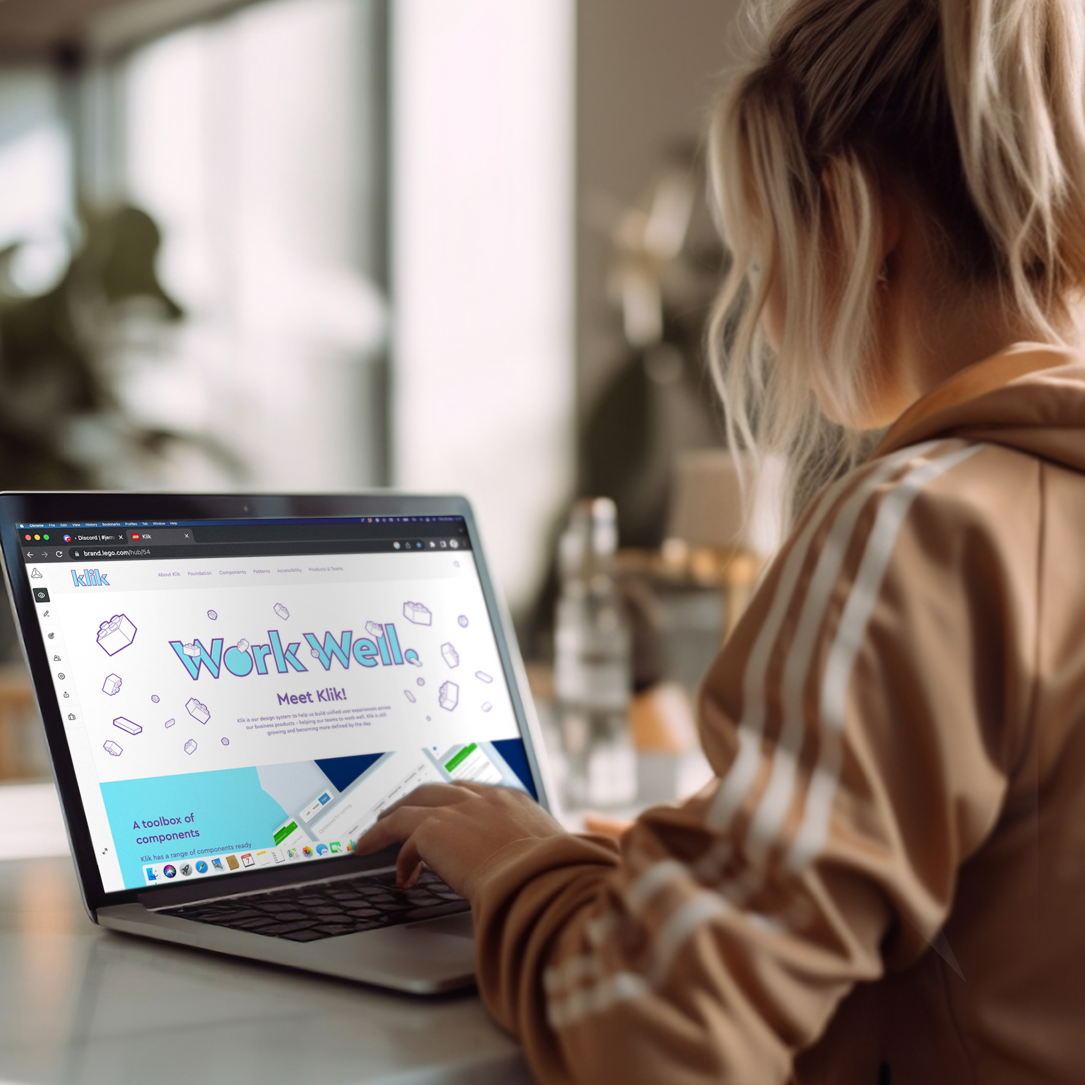 Young female in a tracksuit, using the KLIK platform on a laptop