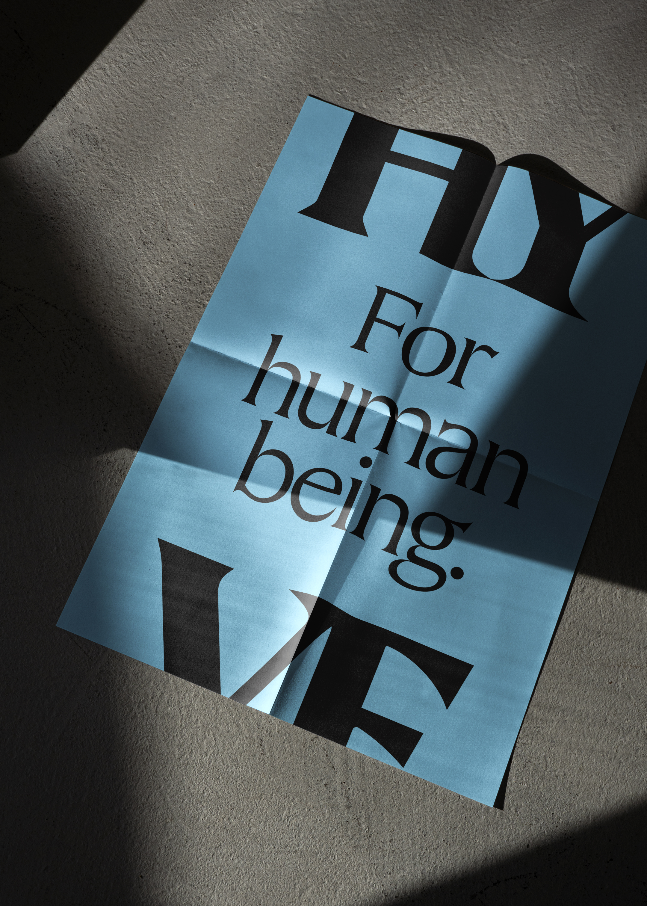 'For human being' large type poster in black on a light blue background, framed with a HY at the top and VE at the bottom.