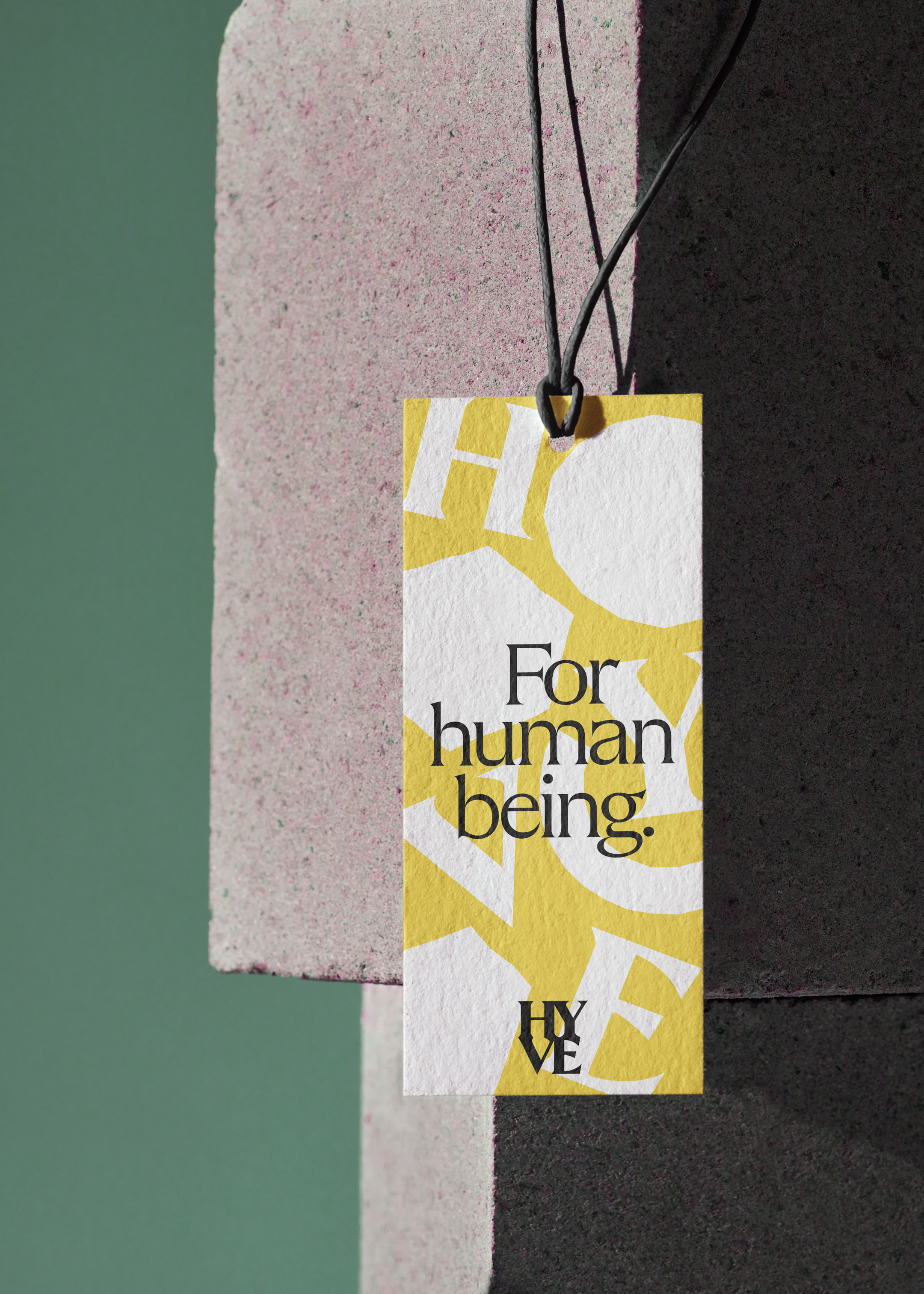 'For human being' type large on a clothing tag, along with irregular white shapes and the word HYVE in the background, which is yellow.