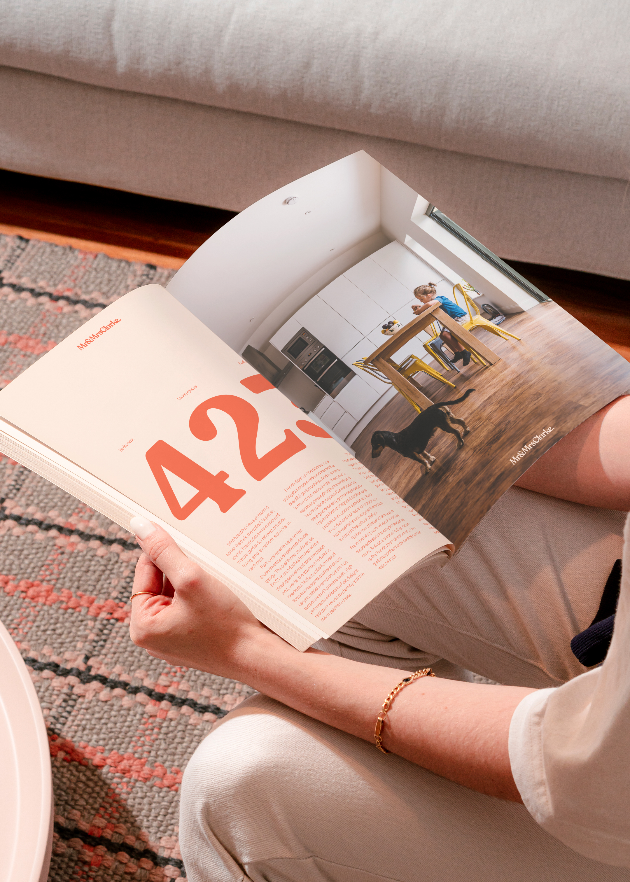 A woman holding an open brochure, showing property details of written specifications on the left and a full page image on the right.