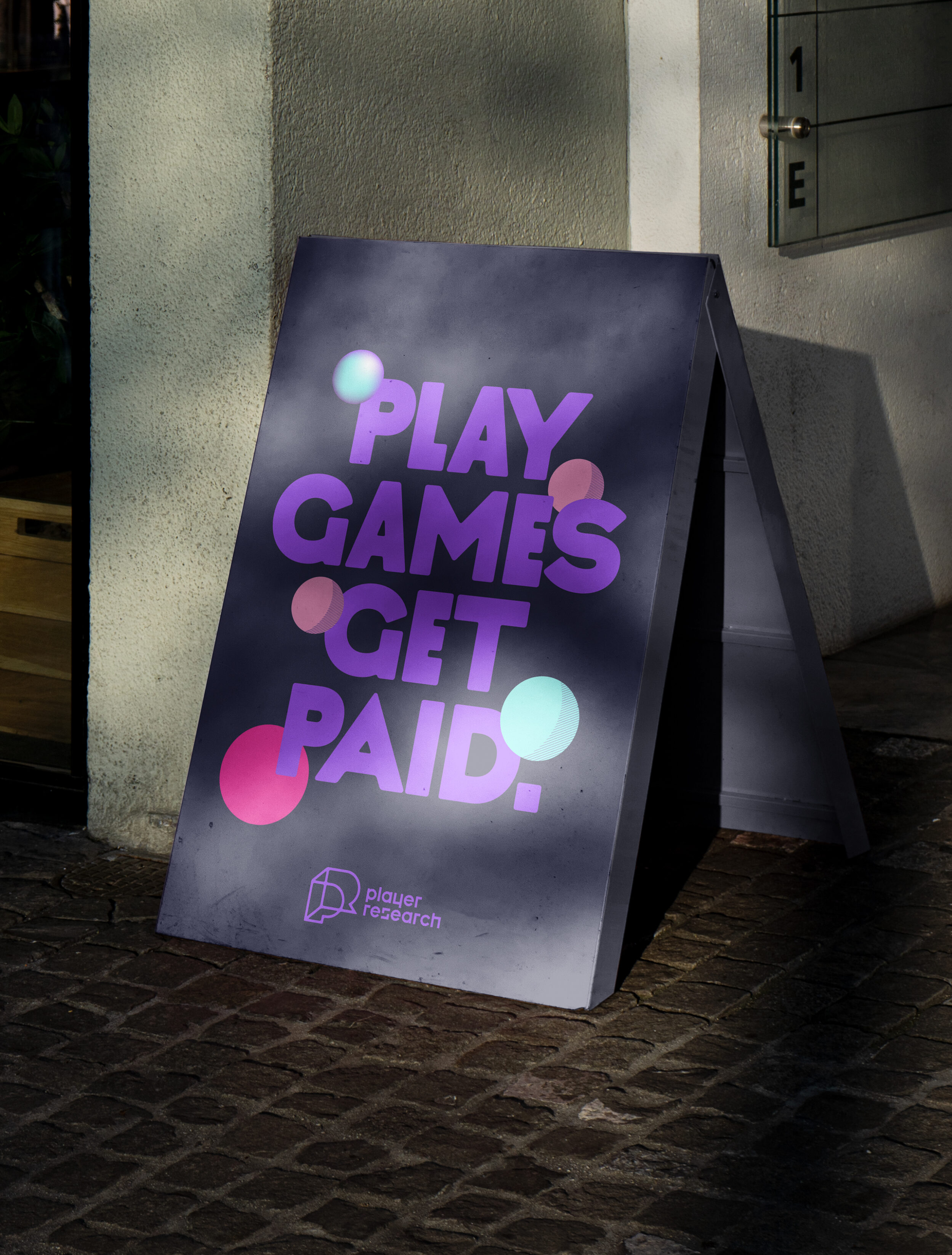 A board next to wall displays text - play games get paid.