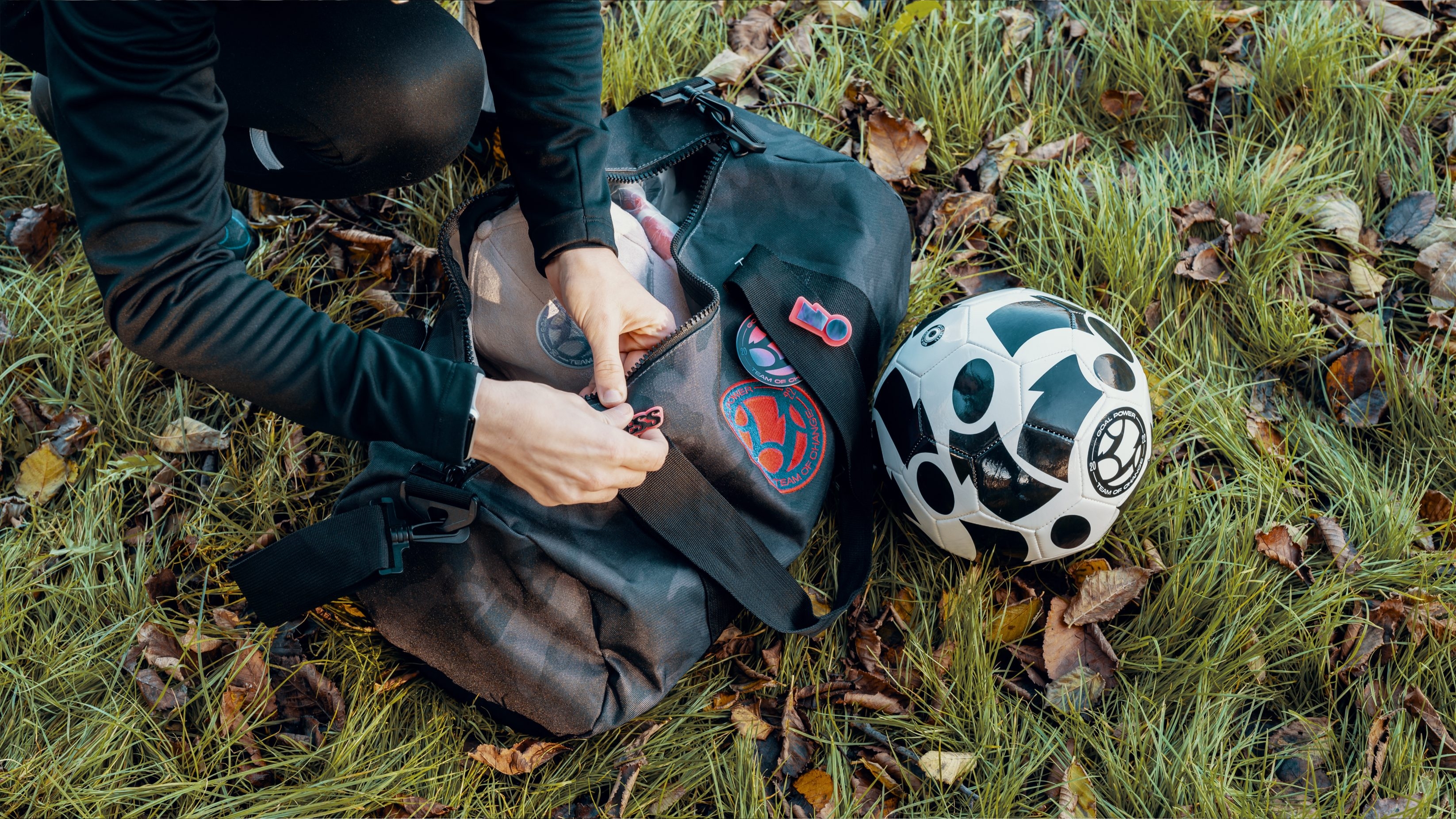 A female footballer adding a Goal Power badge to their training bag