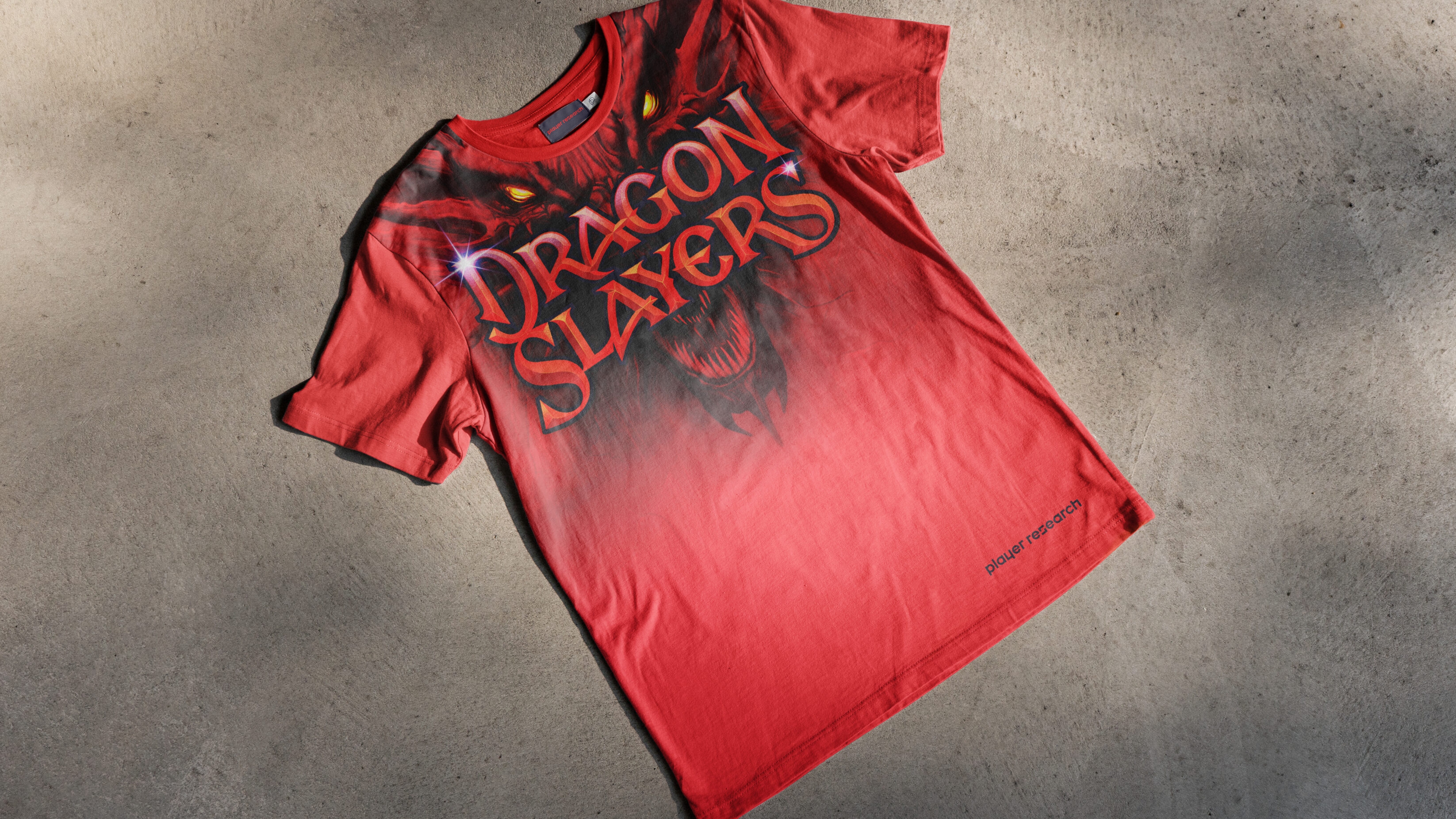 Galaxy Defenders visual on a red t-shirt, laying on a concrete floor