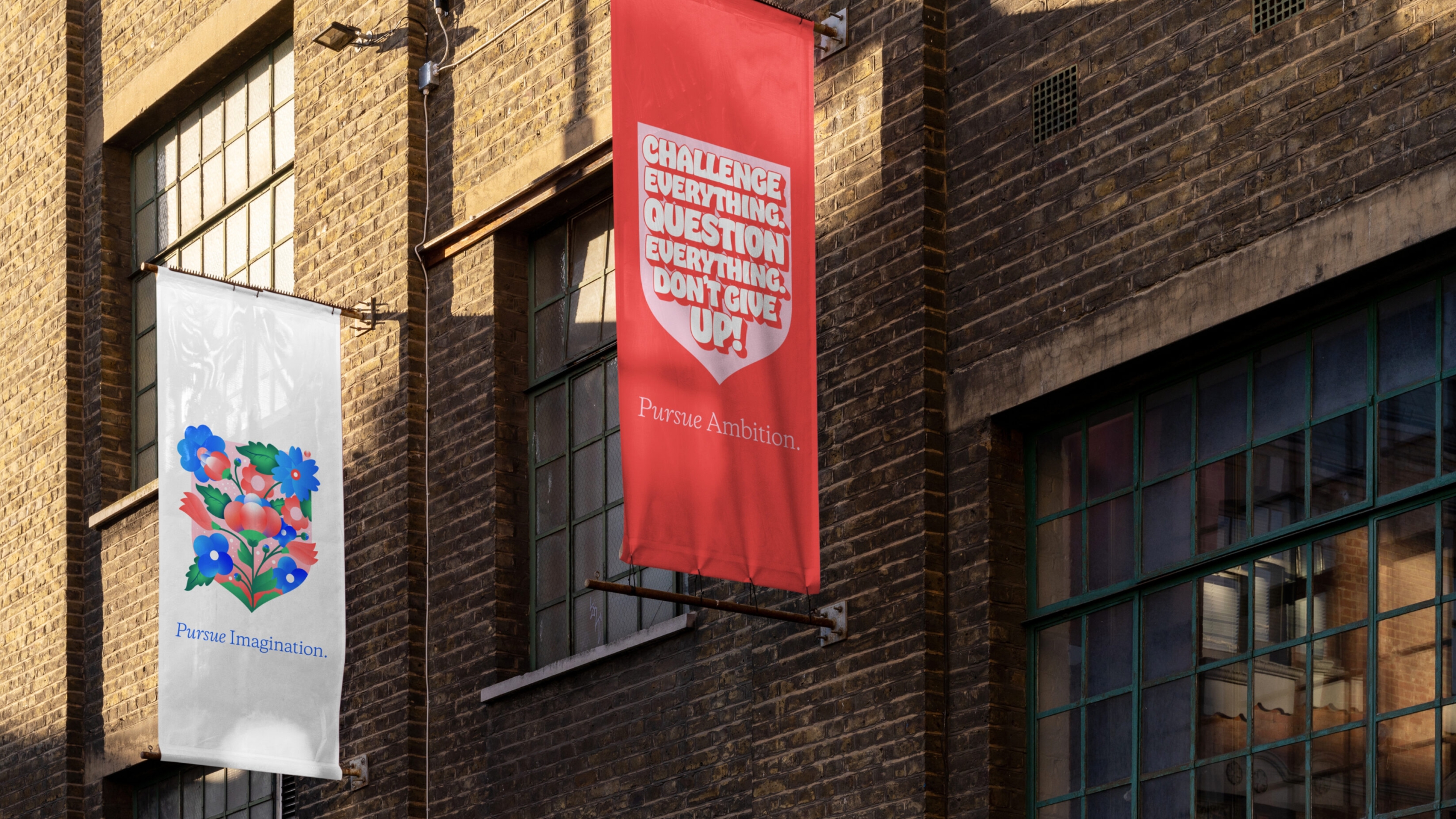 Two vertical banners hanging off the side of a building, with branded shields on them.