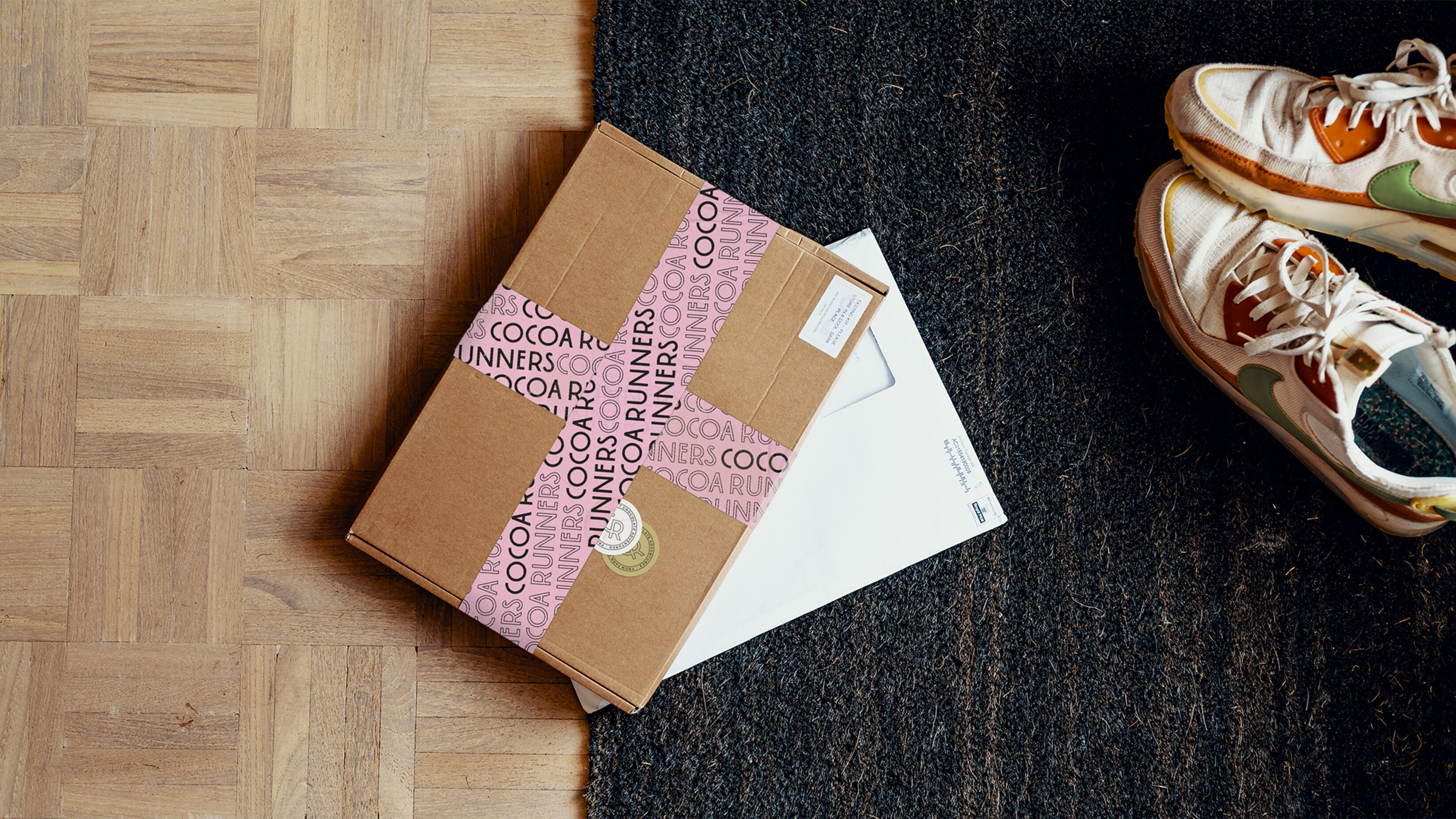 Subscription box laying on a doormat in a home.