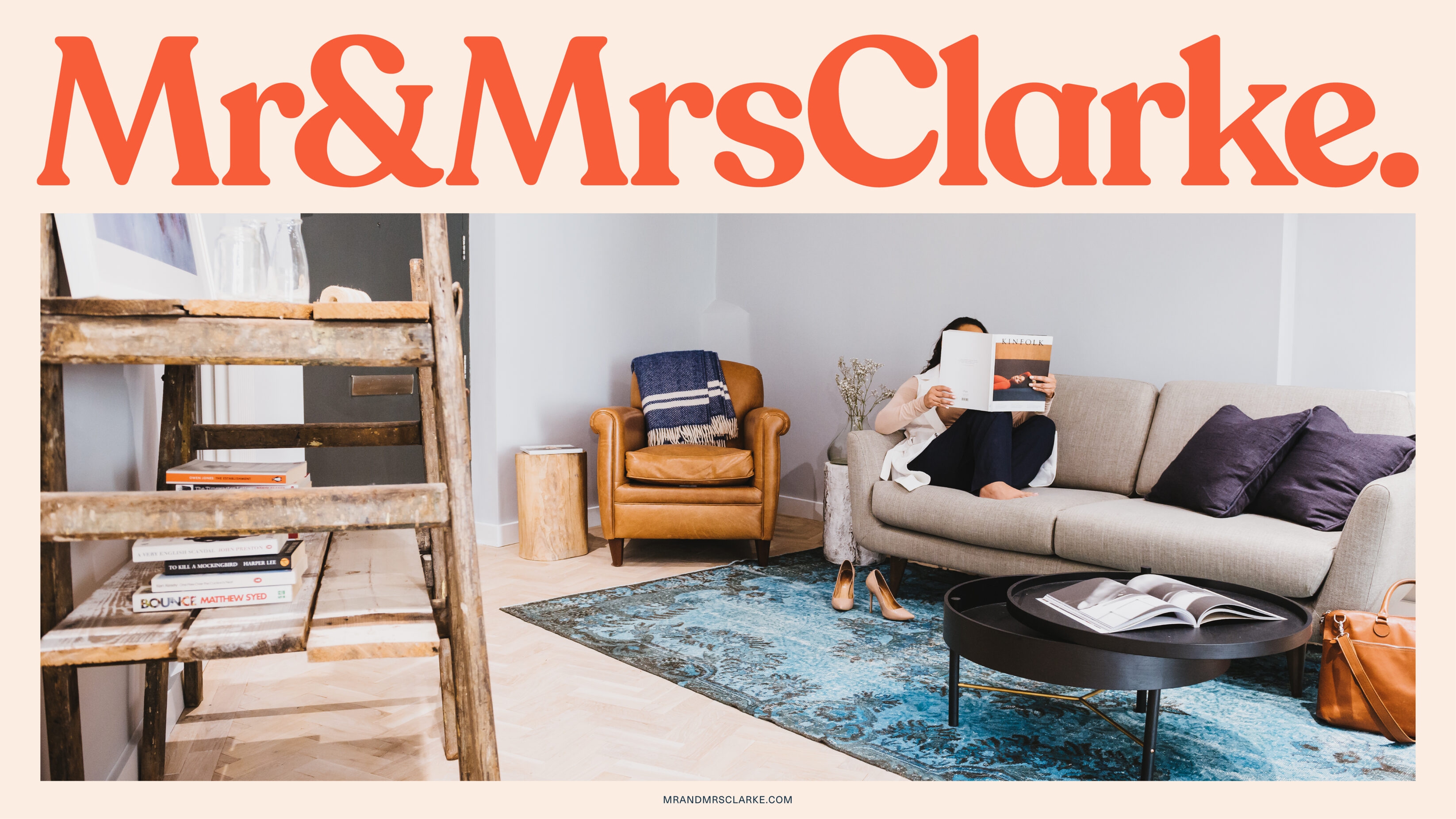Comforting home image of a woman reading a magazine on a grey sofa. Mr and Mrs Clarke large wording above the image.