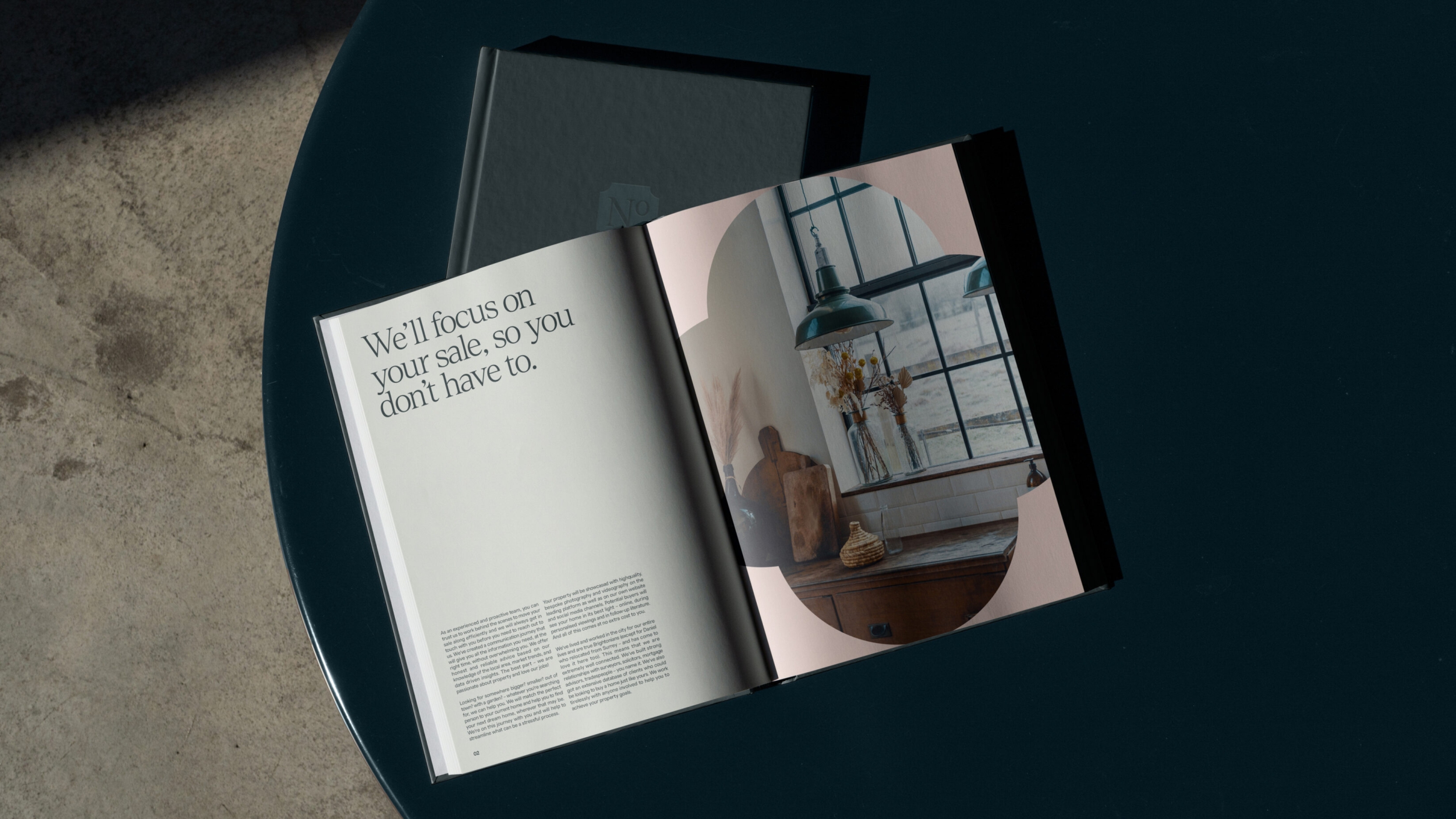 Sales brochure, open, and laying on a dark blue table.