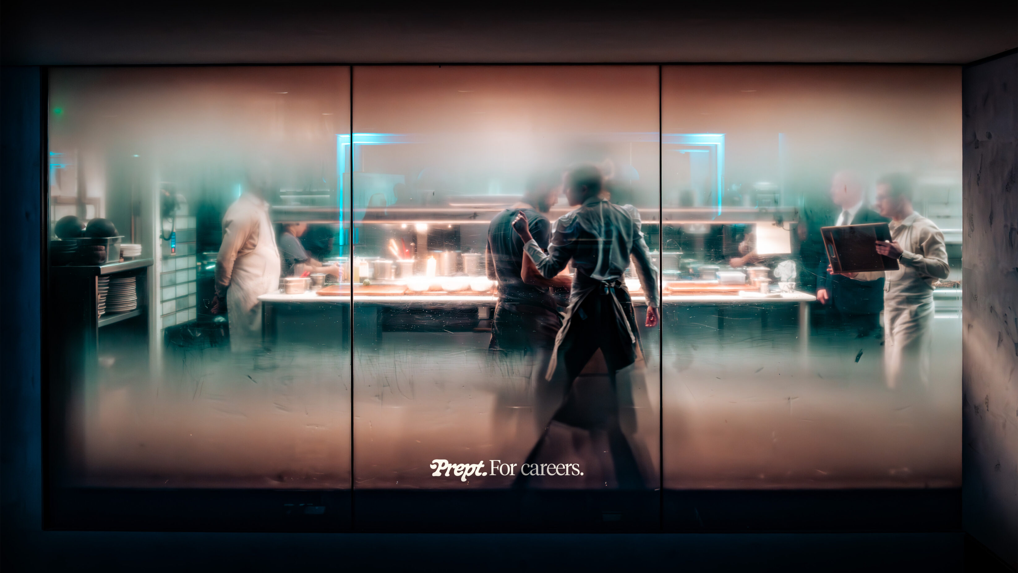 Chefs in a kitchen, partly obscured behind steamy windows