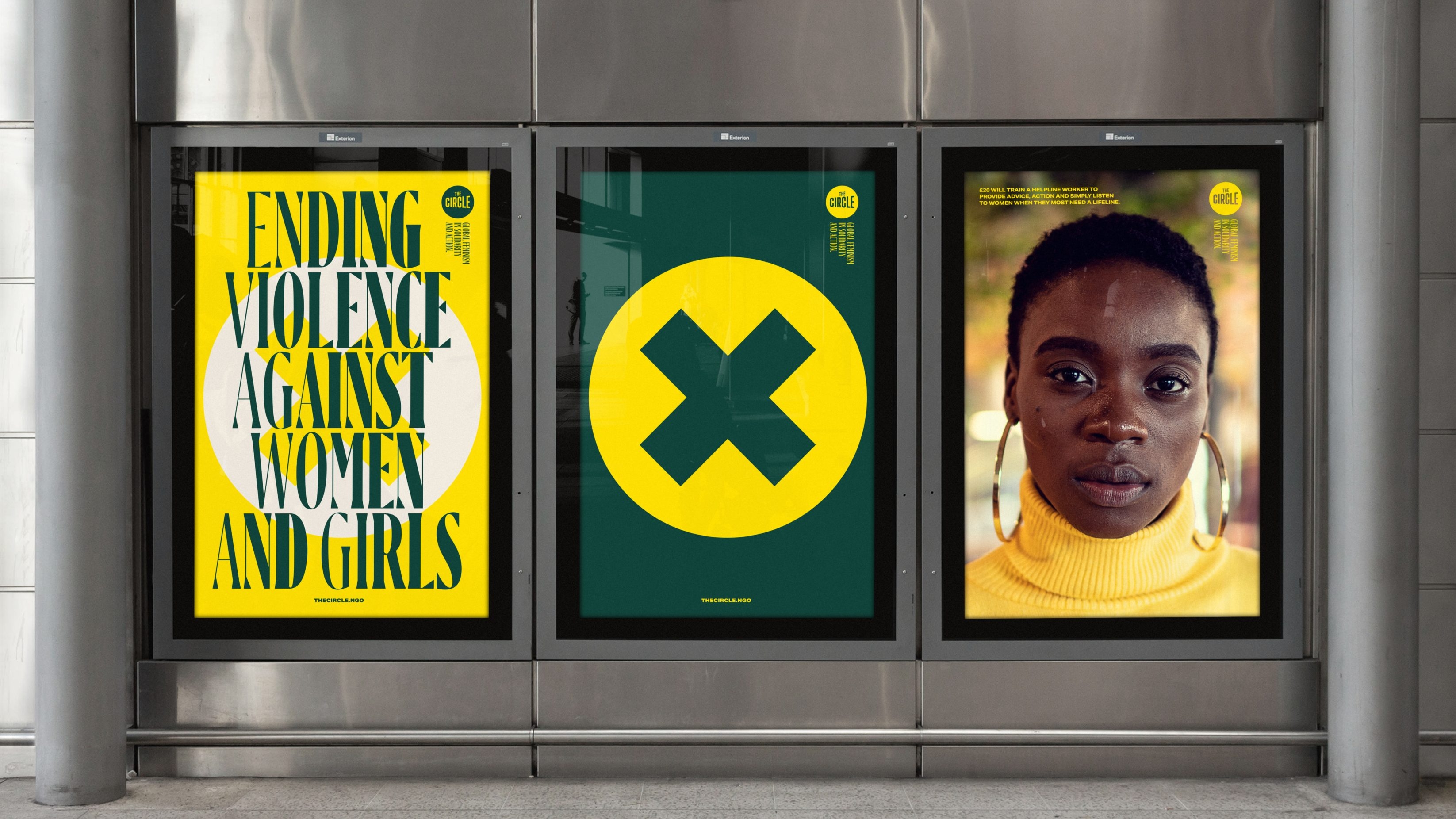 A triad of posters on the wall of an underground station. The primary colour is a bright yellow and the first reads 'Ending Violence Against Women and Girls', the second is of a bold yellow circle with a cross in the middle on a dark green background and the third is of a black woman with short hair and large gold loops wearing a yellow turtleneck.