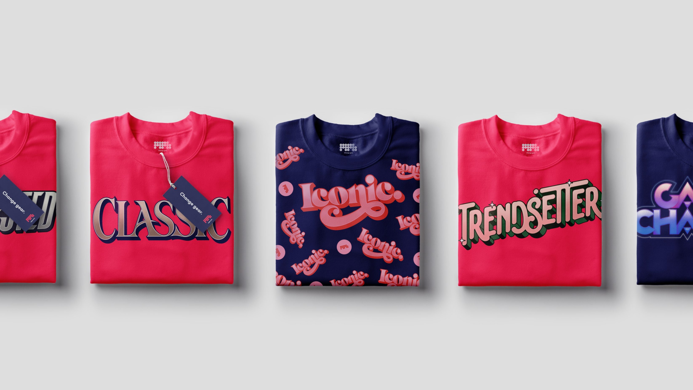 A set of folded pink or blue t-shirts each with keywords like 'classic', 'iconic' and 'trendsetter' in various font styles.