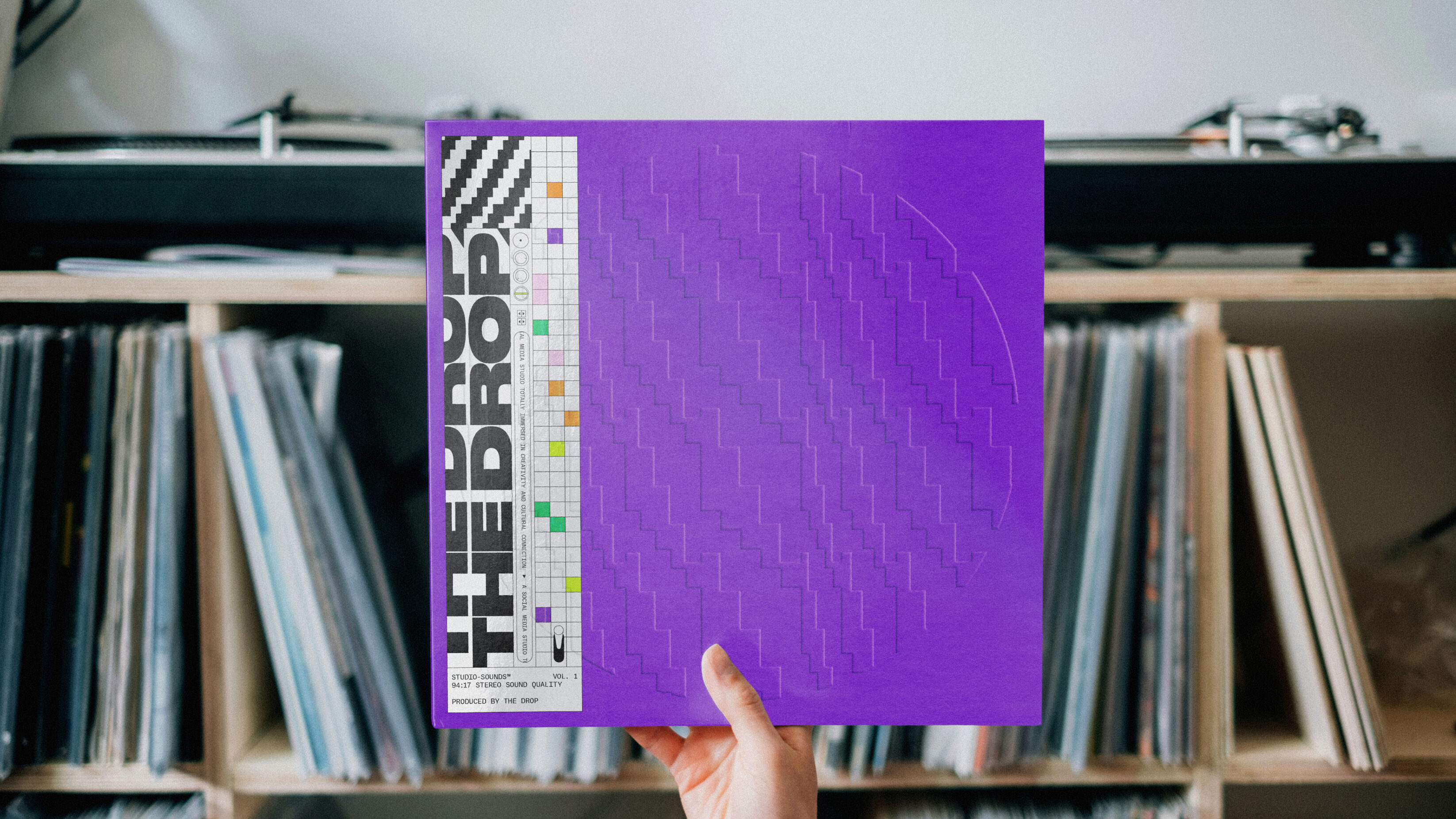 The Drop branded vinyl sleeve, with a debossed pattern and on purple card