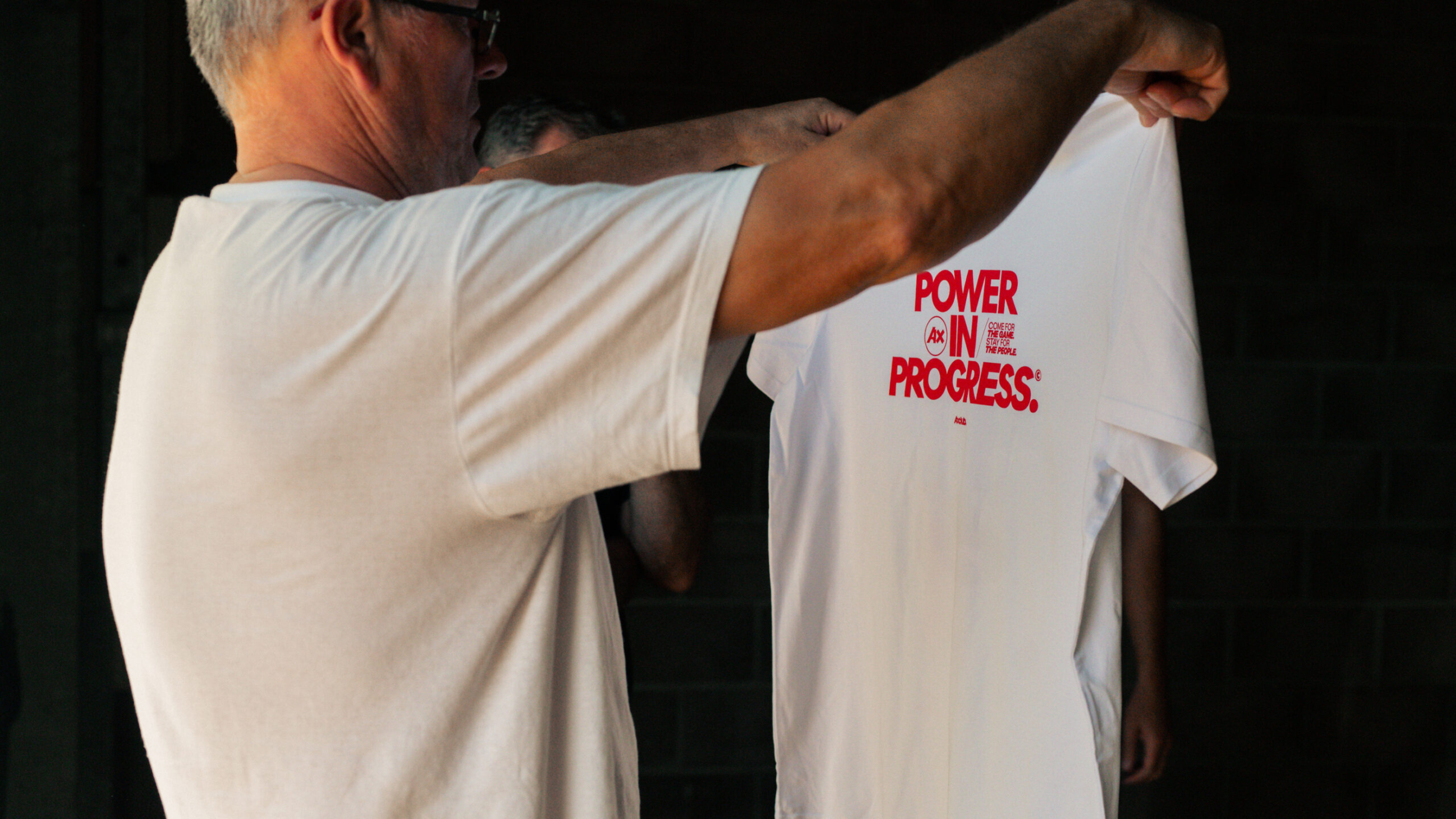 Power in Progress white t-shirt with red text.